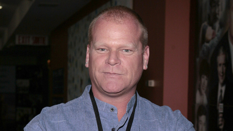 Mike Holmes standing in a denim shirt.