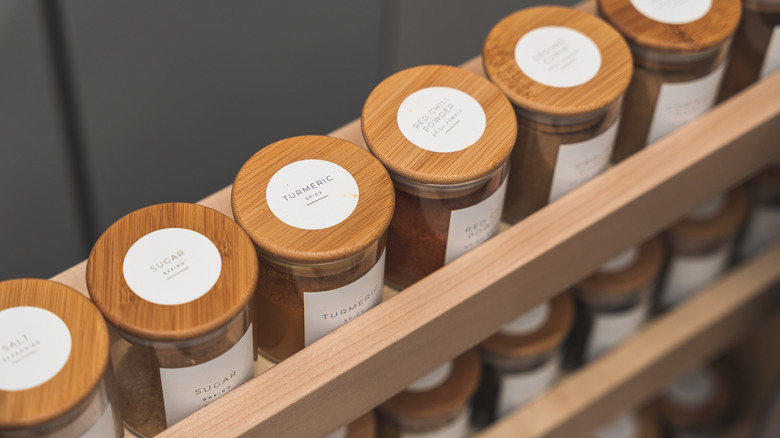 Pull out spice wrack with neat, wood-topped bottles