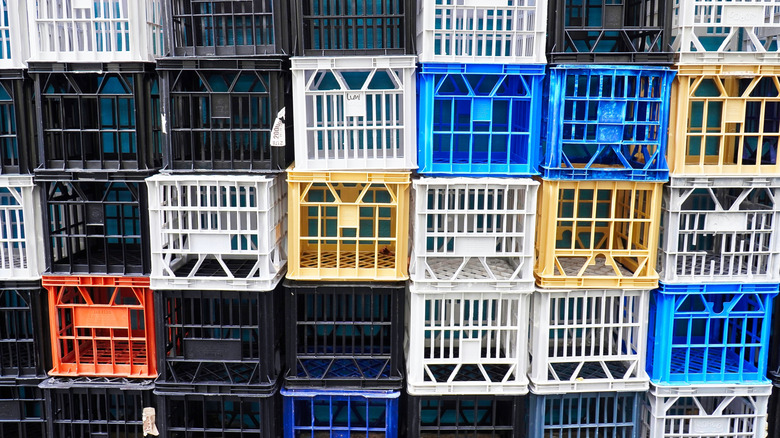 A wall of empty, multi-colored milk crates
