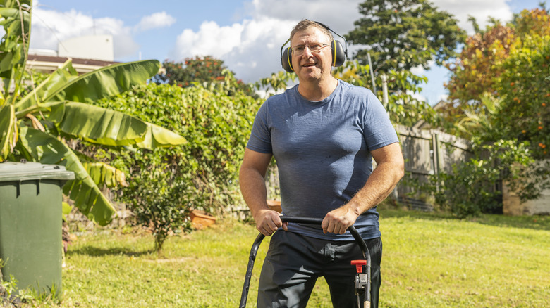 Man mowing the lawn with headphones