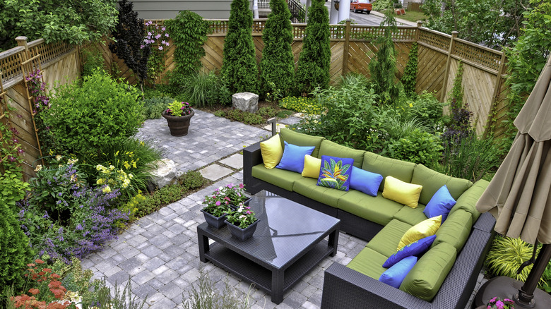 small back yard with seating area, stone pavers, and greenery