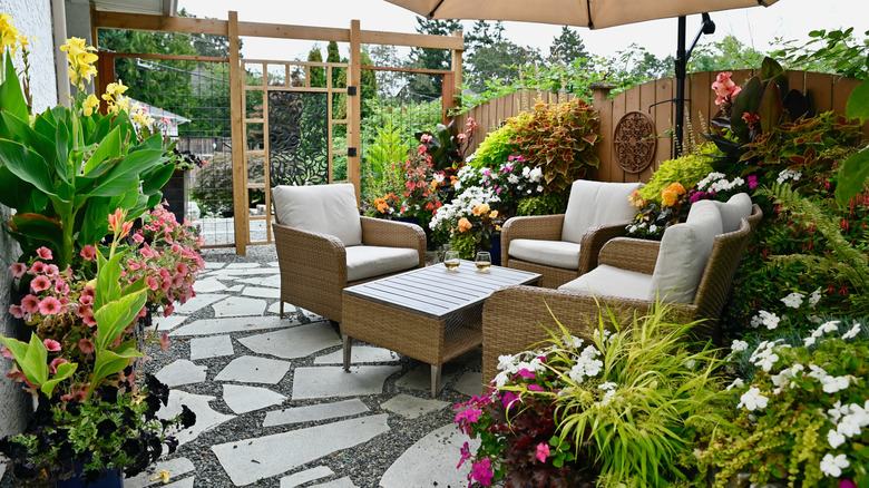 outdoor area featuring plenty of plants, stone, and woven furniture