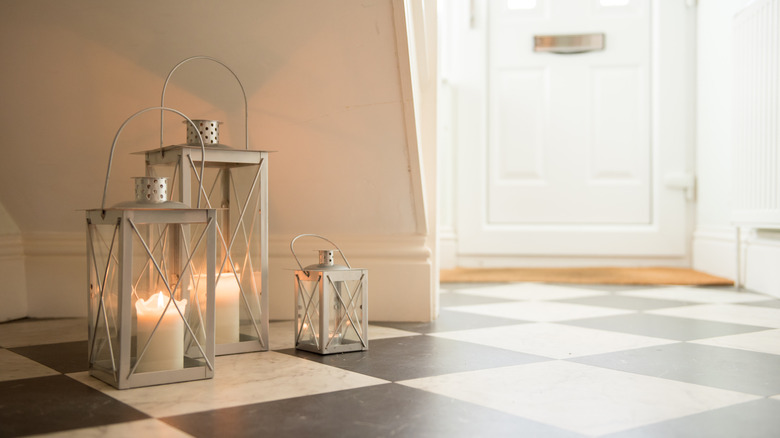 metal lanterns with candles on checkerboard floor