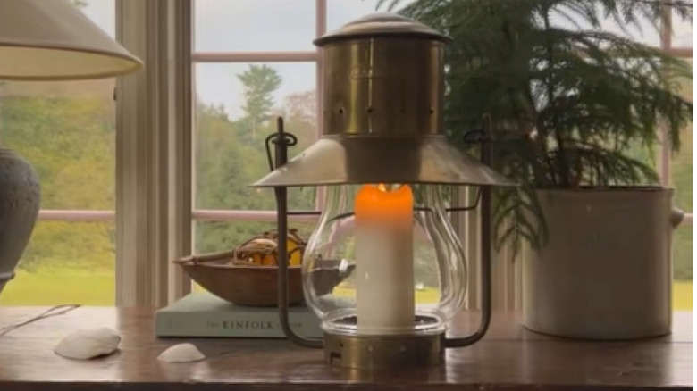 A vintage lantern sitting on a wooden table.