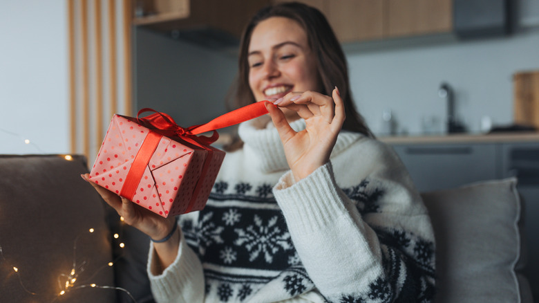 A person ties a bow around a present