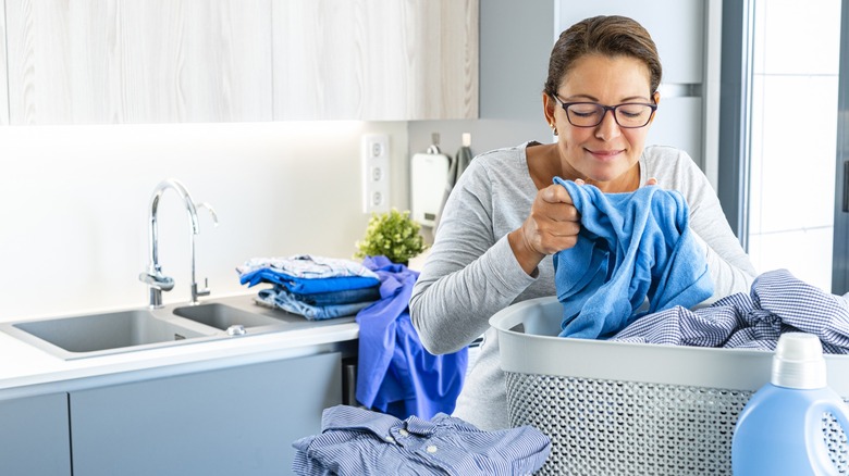 Happy woman smelling laundry