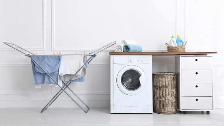 A laundry room with a drying rack inside
