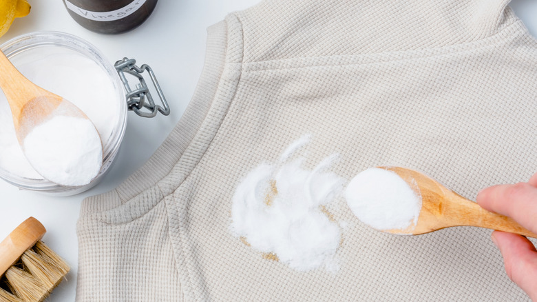A person uses baking powder to remove a stain