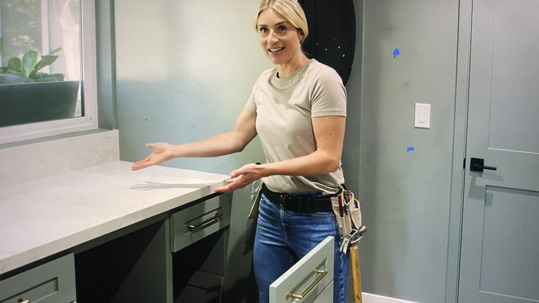 Jasmine Roth shows off the hidden desk in the laundry room she designed