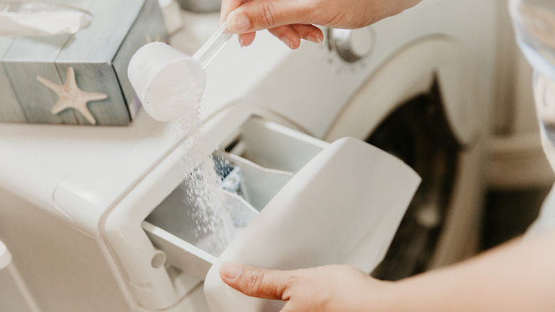 Pouring laundry detergent in washing machine
