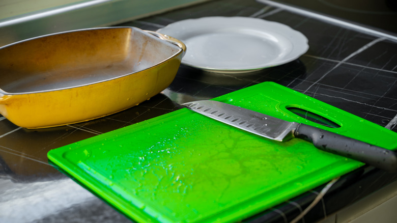 Plastic cutting board with salt and spices on the table