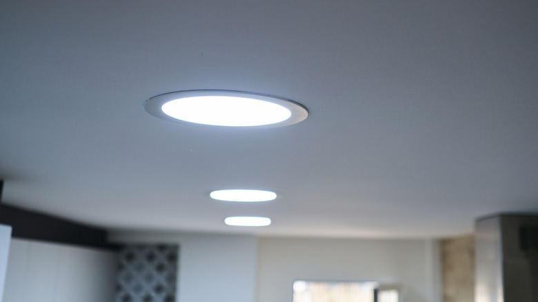 A row of LED ceiling lights are all turned on in a room.