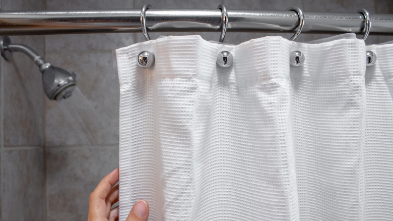 A hand drawing a luxurious fabric shower curtain
