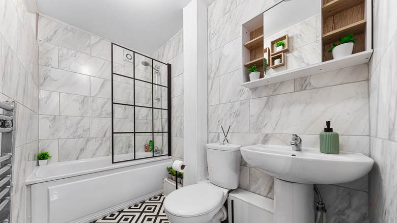 A bathroom with a framed glass shower screen