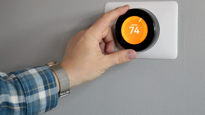 Man hand adjusting thermostat