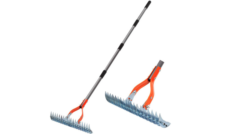 A metal thatch rake with orange accents