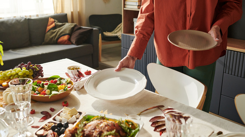 person removing table setting from table