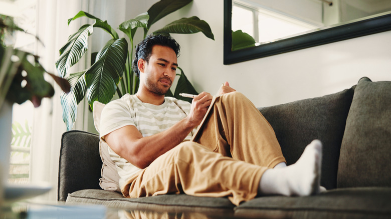 man planning out dinner party schedule on notebook