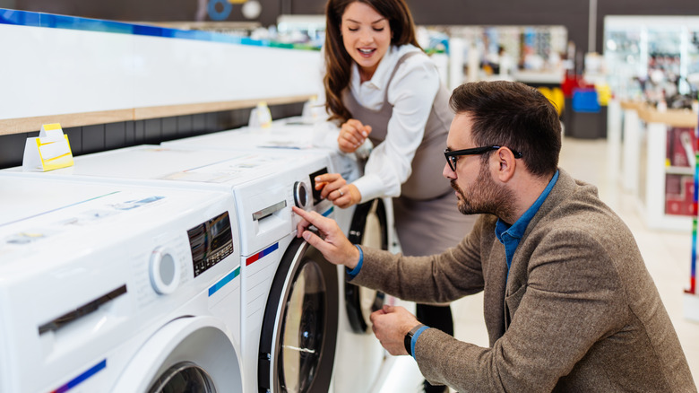 A couple looking at clothes dryers in a store