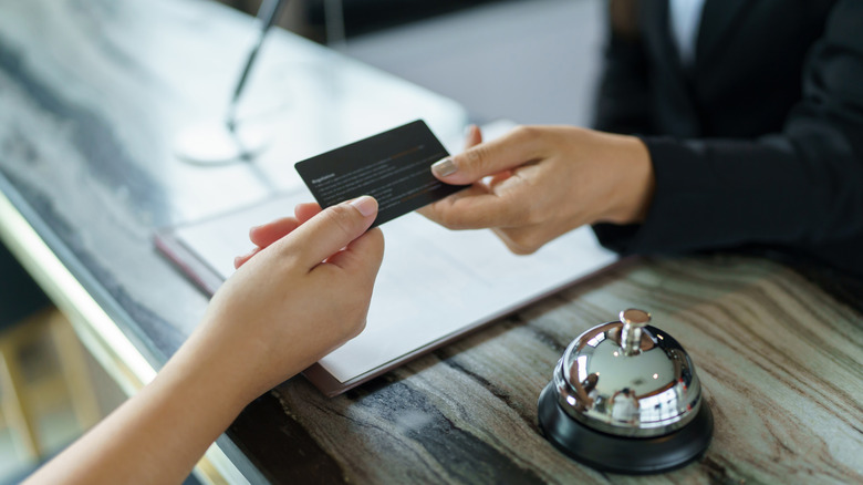 Checking into hotel concierge giving key card
