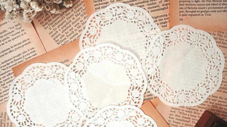 White paper doilies laying flat on top of aged book pages.