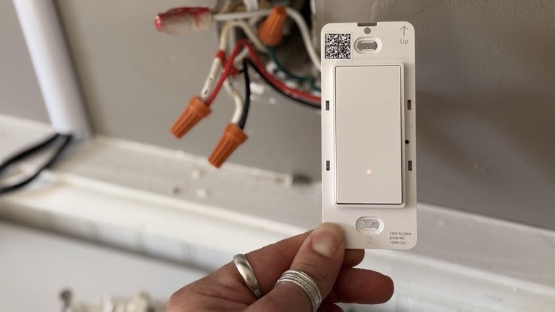 a person installing an Amazon Basics smart light switch