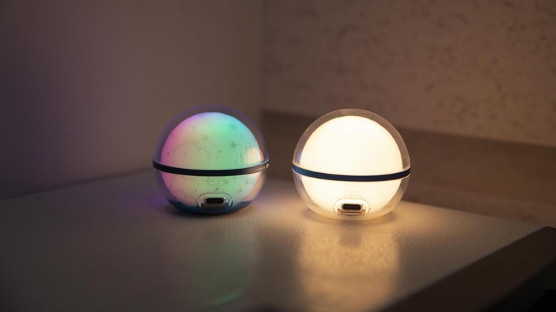 Two Olight Sphere C lights glowing on a table