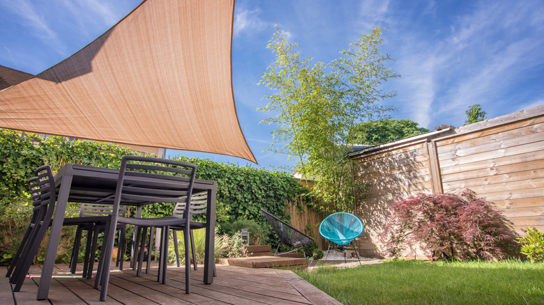 a shade sail in a modern backyard patio space.