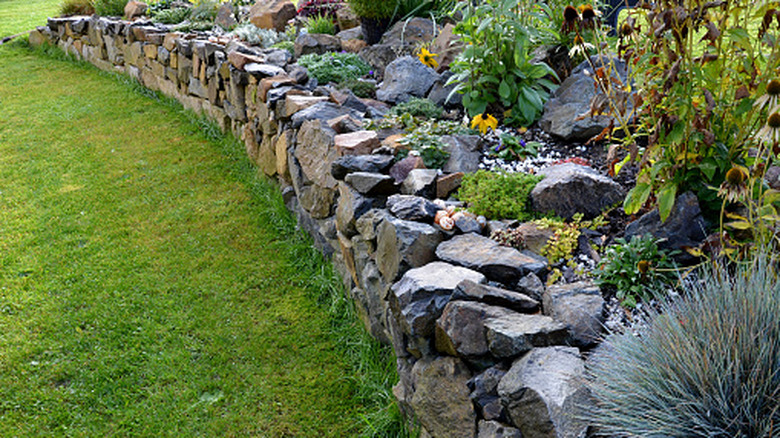 a stone retaining wall in a landscape