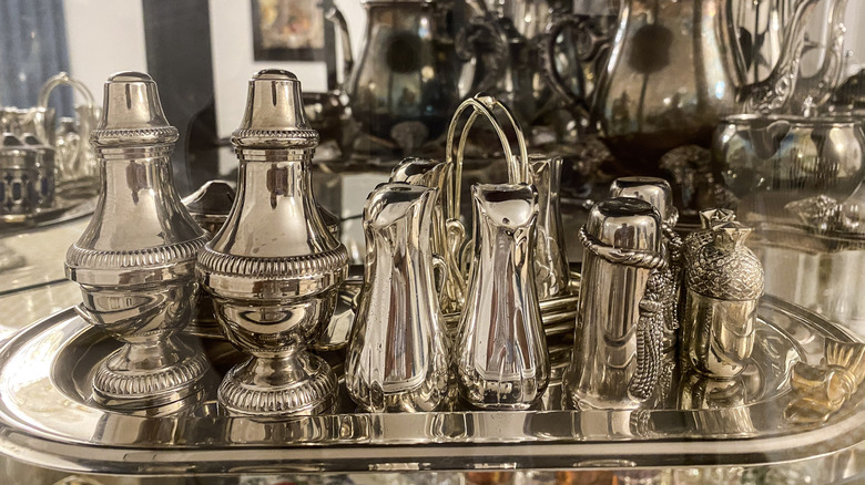 Collection of various salt and paper shakers on a metal tray