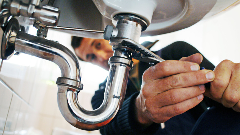 plumber removing a pipe on a bathroom sink