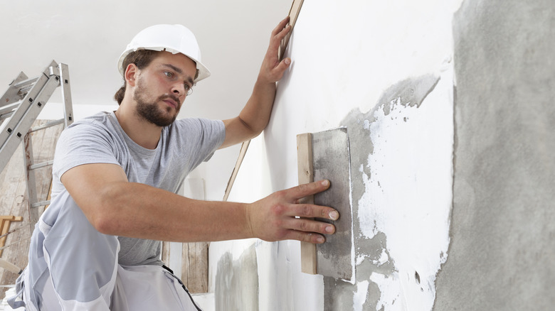 person plastering a wall