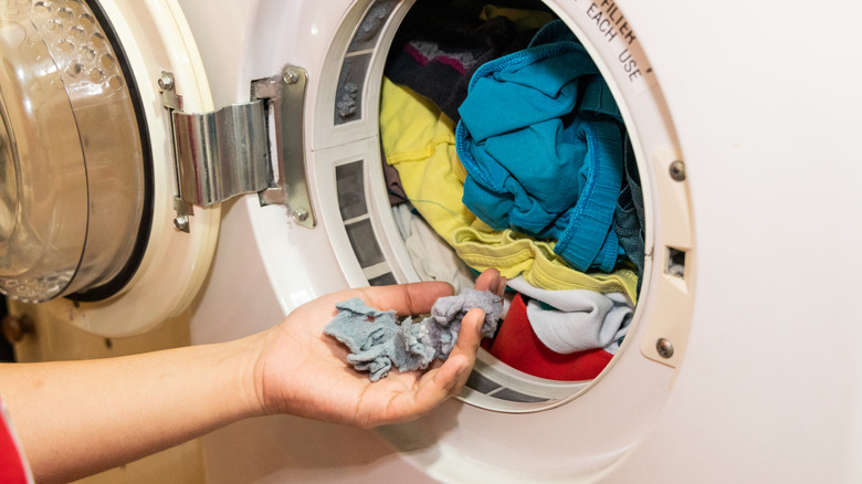 hand holding lint by dryer