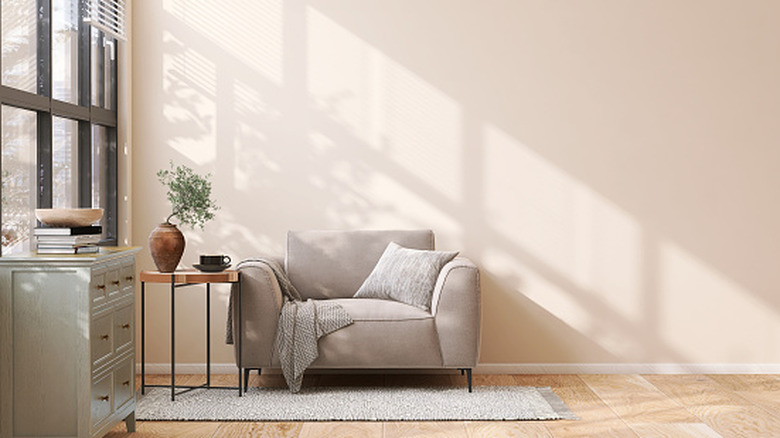 A beige living room chair up against a wall