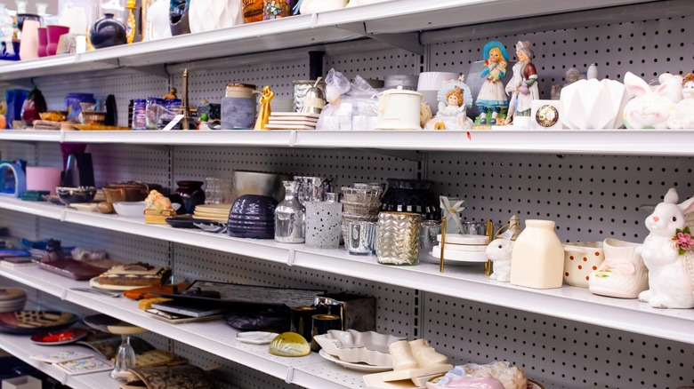 Donated porcelain and glass goods on shelves at a Goodwill thrift store.