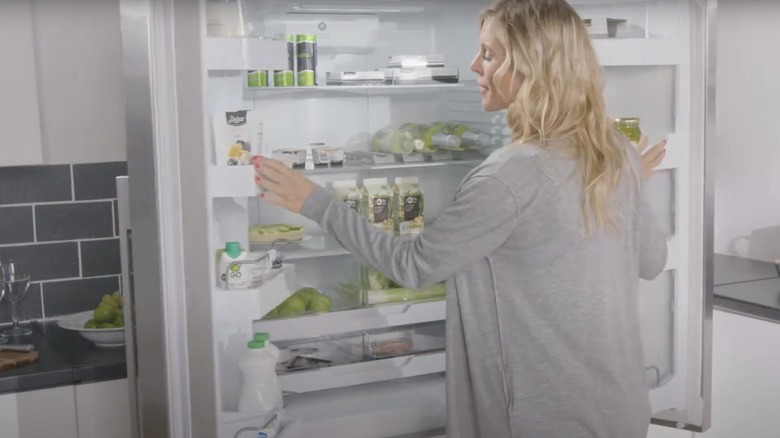 A woman opening a Fisher & Paykel refrigerator