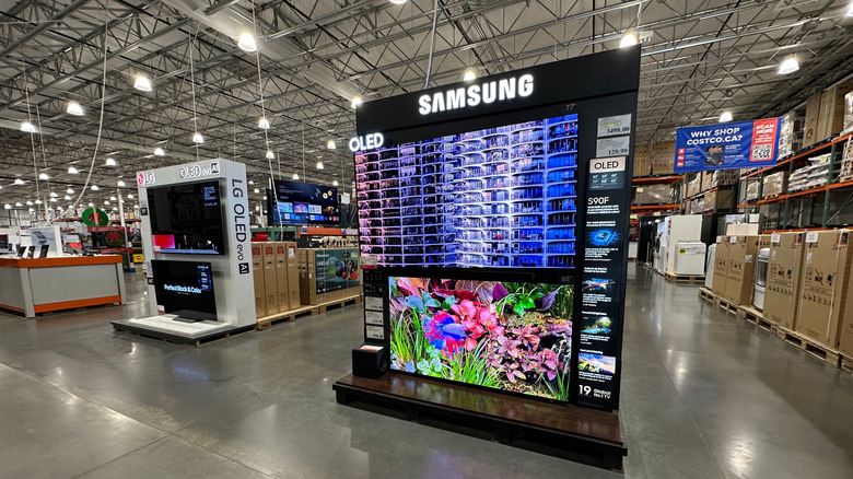 Inside a large Costco store showing a range of TVs for sale
