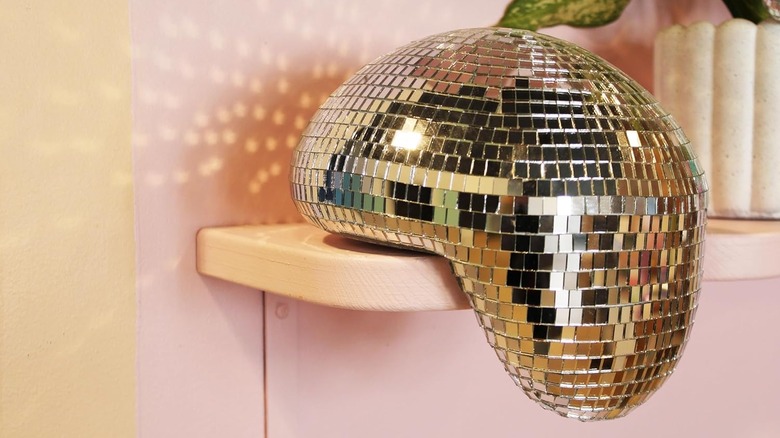 A melting disco ball on a pink shelf