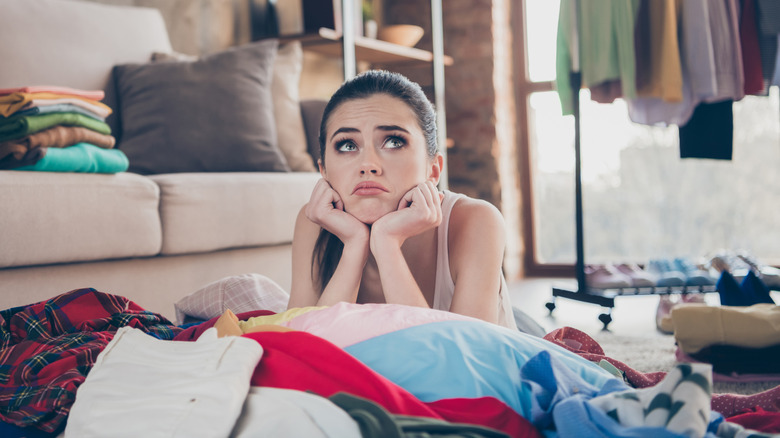 Woman leaning on pile of clutter