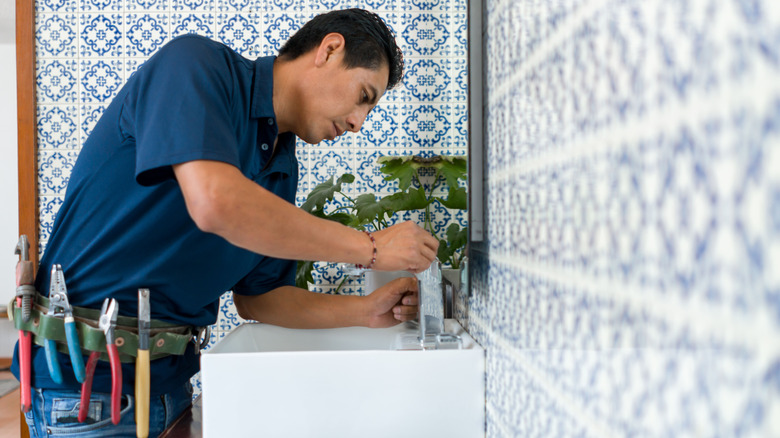 Man repairing bathroom sink faucet