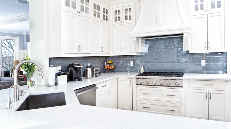 Kitchen with white cabinets and blue backsplash