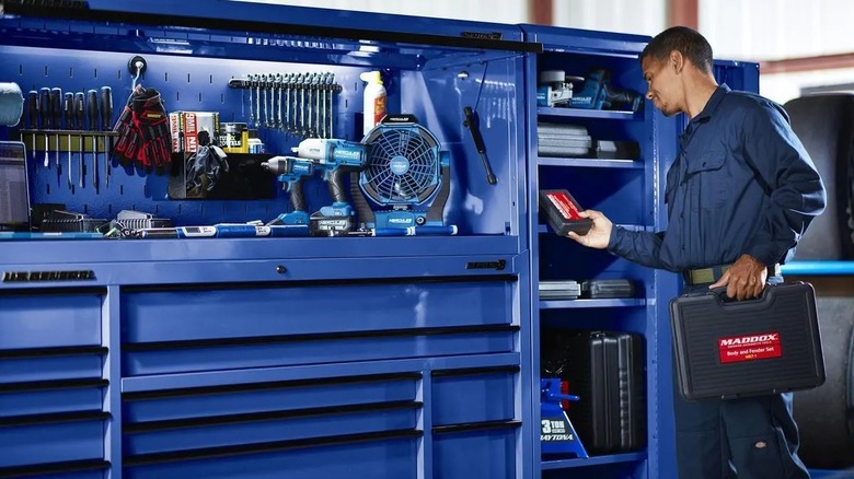 Person retrieving items from the end locker, which is attached to a roll cab to create a large workspace