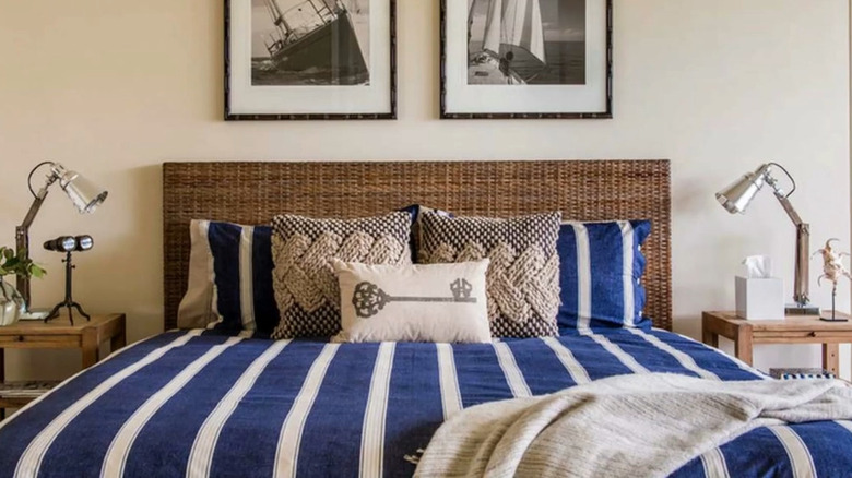 A blue and white bedspread with sailboat artwork gives a coastal vibe in a bedroom