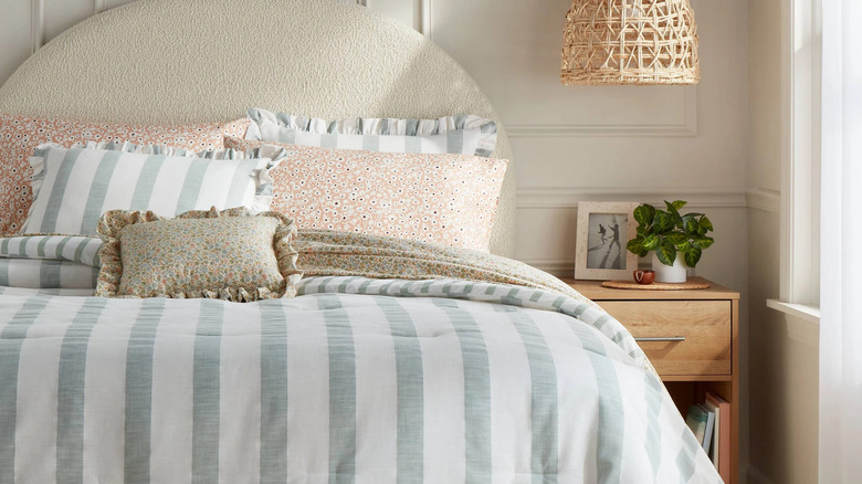 Striped pillows with frills paired with soft floral prints creates a modern cottage aesthetic