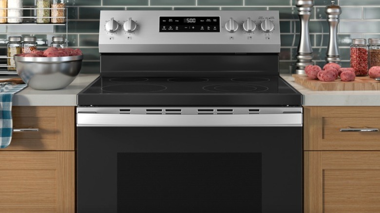 GE freestanding 5-burner glass top electric range between kitchen counters