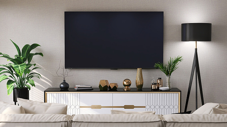 A stylish living room with a massive flat screen TV mounted to the wall.