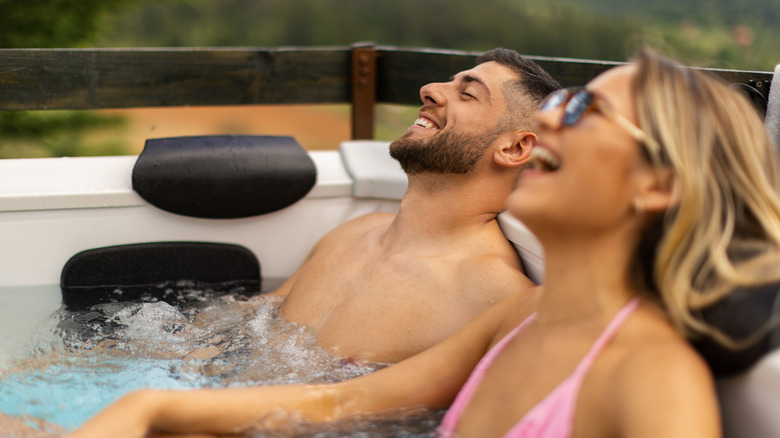 A couple soaking in a backyard hot tub.