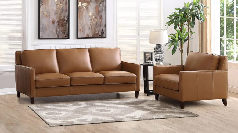 A brown leather couch set in a white living room