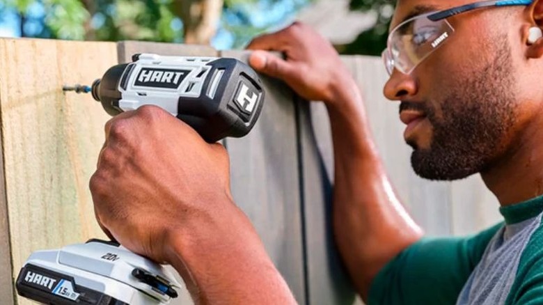 Man using a Hart power tool on a fence
