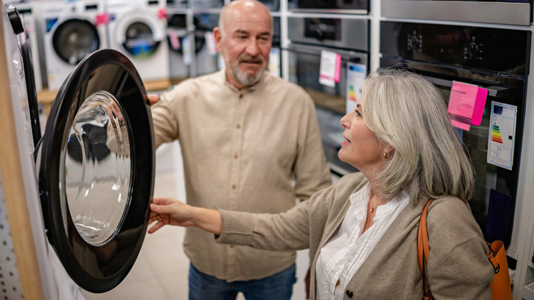 Older couple comparing the features of appliances in a store